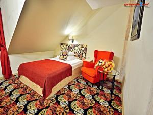 1 dormitorio con 1 cama y 1 silla roja en Karczma Rzym Bydgoszcz S5, en Bydgoszcz