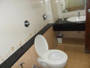 Lotus Comfort - A Pondy Hotel في بونديتْشيري: حمام مع مرحاض ومغسلة