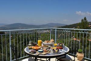 un tavolo con cibo in cima a un balcone di Zimmers at the Forest ad Amirim