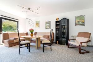 ein Wohnzimmer mit einem Sofa, einem Tisch und Stühlen in der Unterkunft RügenHerz Piratenhaus in Parchtitz