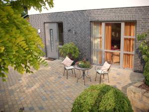 a patio with chairs and a table in front of a building at Villa Fleurie in Schledehausen