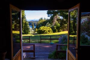 an open door to a porch with a view of a yard at Hosteria Las Cartas in San Carlos de Bariloche