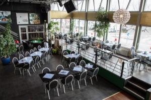 een restaurant met tafels en stoelen in een kamer met ramen bij Wärs - Wärdshuset på Dal in Mellerud