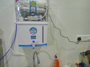 a hair dryer hanging on a wall next to a sink at H2O Apartment in Cameron Highlands