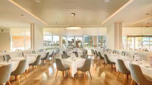 a restaurant with white tables and chairs and windows at Hipotels Playa de Palma Palace&Spa in Playa de Palma +37 photos