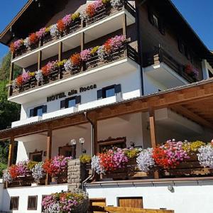 um edifício com muitas caixas de flores sobre ele em Hotel Alla Rocca em Varena