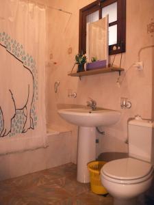 a bathroom with a sink and a toilet and a shower at Private Holiday Apartment in Tarrafal