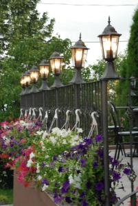 a fence with a bunch of lights and flowers at Hotel Liliacul in Cluj-Napoca