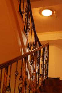 a staircase with a wrought iron railing and a light at Hotel Liliacul in Cluj-Napoca