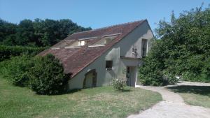 una pequeña casa blanca con techo rojo en Villa Dikaria en Montacher