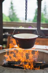 a pot of soup over a fire in a cauldron at Pensiunea Vis Alpin Belis in Beliş