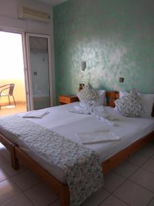 una camera da letto con un grande letto con lenzuola bianche di Haus Sofis a Kinira