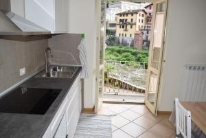 a kitchen with a sink and a large window at residenza la roggia in Varallo