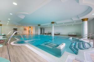 a large swimming pool with a slide in a building at Iberostar Selection Andalucia Playa in Chiclana de la Frontera