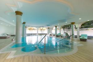 a pool in the middle of a building with columns at Iberostar Selection Andalucia Playa in Chiclana de la Frontera