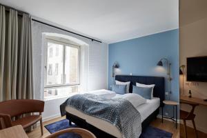 sypialnia z dużym łóżkiem z niebieską ścianą w obiekcie Copenhagen Strand w Kopenhadze