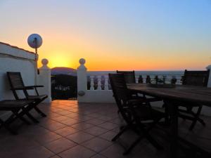 a patio with a table and chairs and the sunset at Villa Amare in Benissa