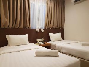 a room with two beds and a window at Hotel Asia in Kuah