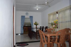 a dining room with a wooden table and chairs at Nest Inn in Trincomalee