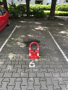 a red suitcase sitting on the ground in a parking lot at Apartament Karmelicka 19 Muzeum Polin in Warsaw