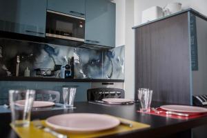 a kitchen with a table with plates and glasses on it at De briques et de bois in Albi +10 photos