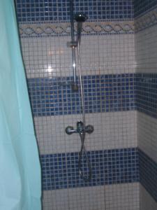 a shower in a blue and white tiled bathroom at Traditional city house in Kalymnos