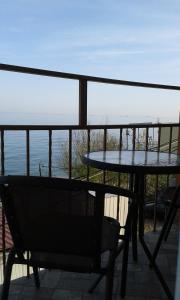 a table and chair on a balcony with a view of the ocean at Apartment Moe More in Odesa