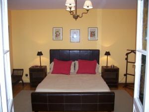 a bedroom with a large bed with red pillows at Quinta del Canal in Tamariz de Campos