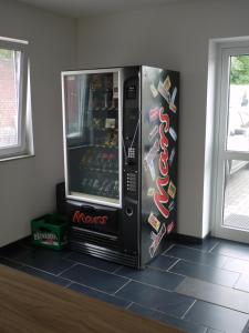 a coca cola vending machine sitting in a room at Ruhrstadtarena Hotel in Herne