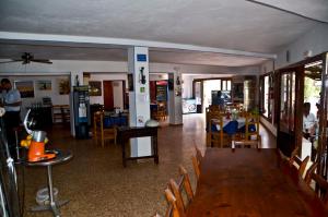 een kamer met tafels en stoelen en een eetkamer bij Hostal Alocs in Es Figueral Beach