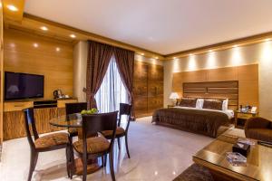 um quarto de hotel com uma cama, uma mesa e cadeiras em Lahoya Verdun em Beirute