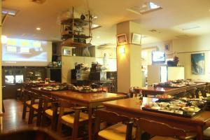 um restaurante com mesas e cadeiras com comida em 伊藤屋 em Zao Onsen