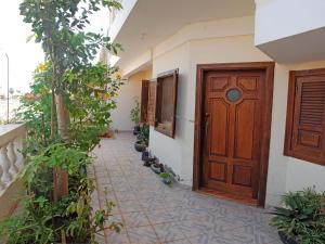 un pasillo con una puerta de madera y algunas plantas en Self-catering Apartment w/ Terrace, en Tarrafal 8 fotos más