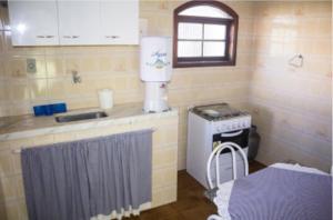a small kitchen with a stove and a window at Ohana Beach in Saquarema +12 photos