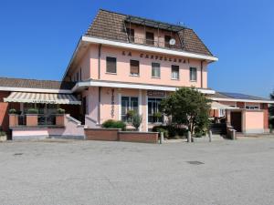 un gran edificio rosa con un cartel en él en Locanda La Castellana, en Castello d'Agogna