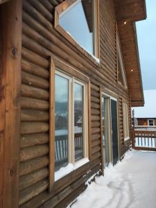 a log house with a balcony with windows at Chalet du Versant Nord in Saint-David-de-Falardeau