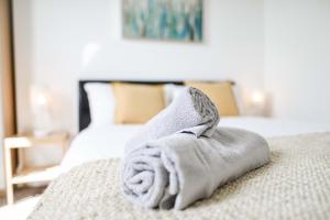 a towel sitting on top of a bed at Modern Central Apartment in Aberdeen
