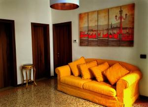 un divano giallo in soggiorno con un dipinto di Casa Giuliana a Venezia