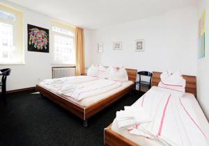 Habitación con 2 camas en una habitación en Hotel Goldener Hahn, en Duisburg