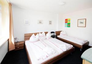 a bedroom with two beds with white sheets at Hotel Goldener Hahn in Duisburg