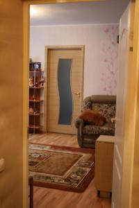 a living room with a couch and a door at Yulia Apartment in Narva