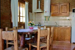 a kitchen with a wooden table with chairs and a sink at Cabañas Calderón II in San Rafael