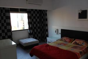 a bedroom with a bed and a chair and a window at Apartment at Milsa Nasr City, Building No. 30 in Cairo