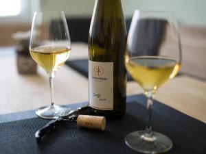 a bottle of white wine and two glasses on a table at Ferienwohnung Sonnendeck in Kröv