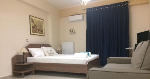a bedroom with a bed and a chair and a blue curtain at Super 36sqm Junior Suite in luxurious picturesque area in Piraeus
