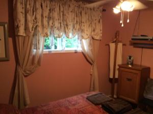 1 dormitorio con 1 cama y una ventana con cortinas en Chez Lulu et Lutin, en Rawdon