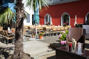 un restaurante con mesas, sillas y una palmera en FT Hotel, en Freiburg im Breisgau