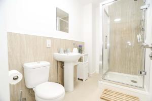 a bathroom with a toilet and a sink and a shower at Modern Central Apartment in Aberdeen +4 photos