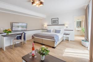 ein Hotelzimmer mit einem Bett und einem Tisch in der Unterkunft Strandgrün Golf- & Spa Resort in Timmendorfer Strand