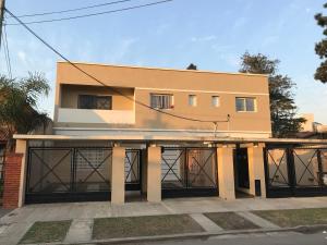 un edificio con dos puertas de garaje delante de él en Mendoza Apartments Ezeiza Airport en Luis Guillón